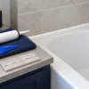 Illustration of bathroom seal maintenance tools beside a bath